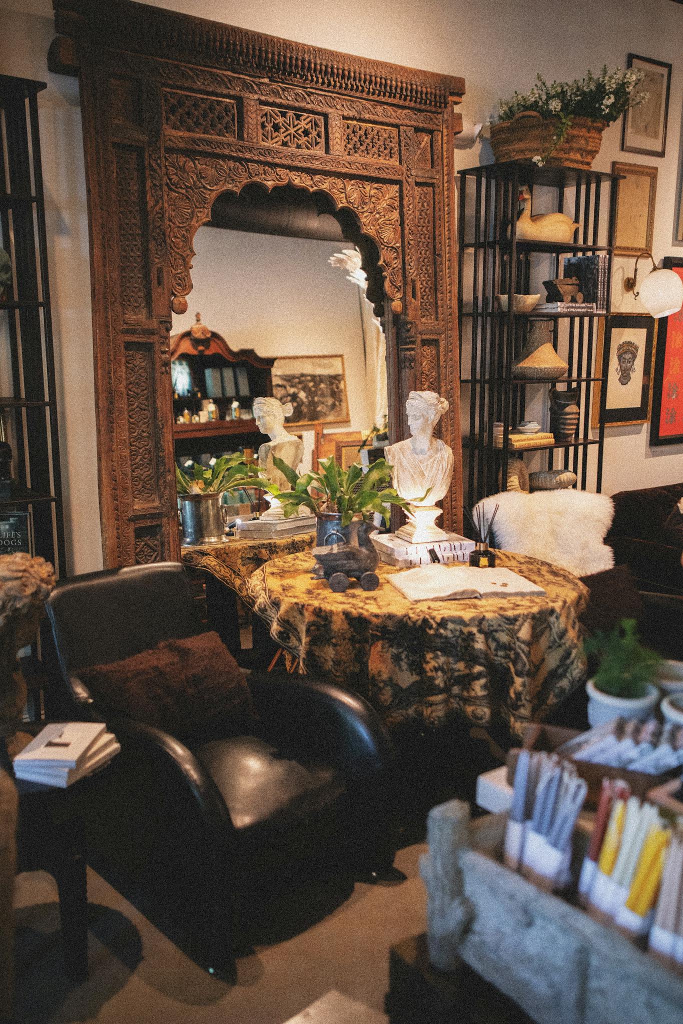 Warm and inviting boutique interior featuring vintage decor, artisan goods, and vibrant plants.